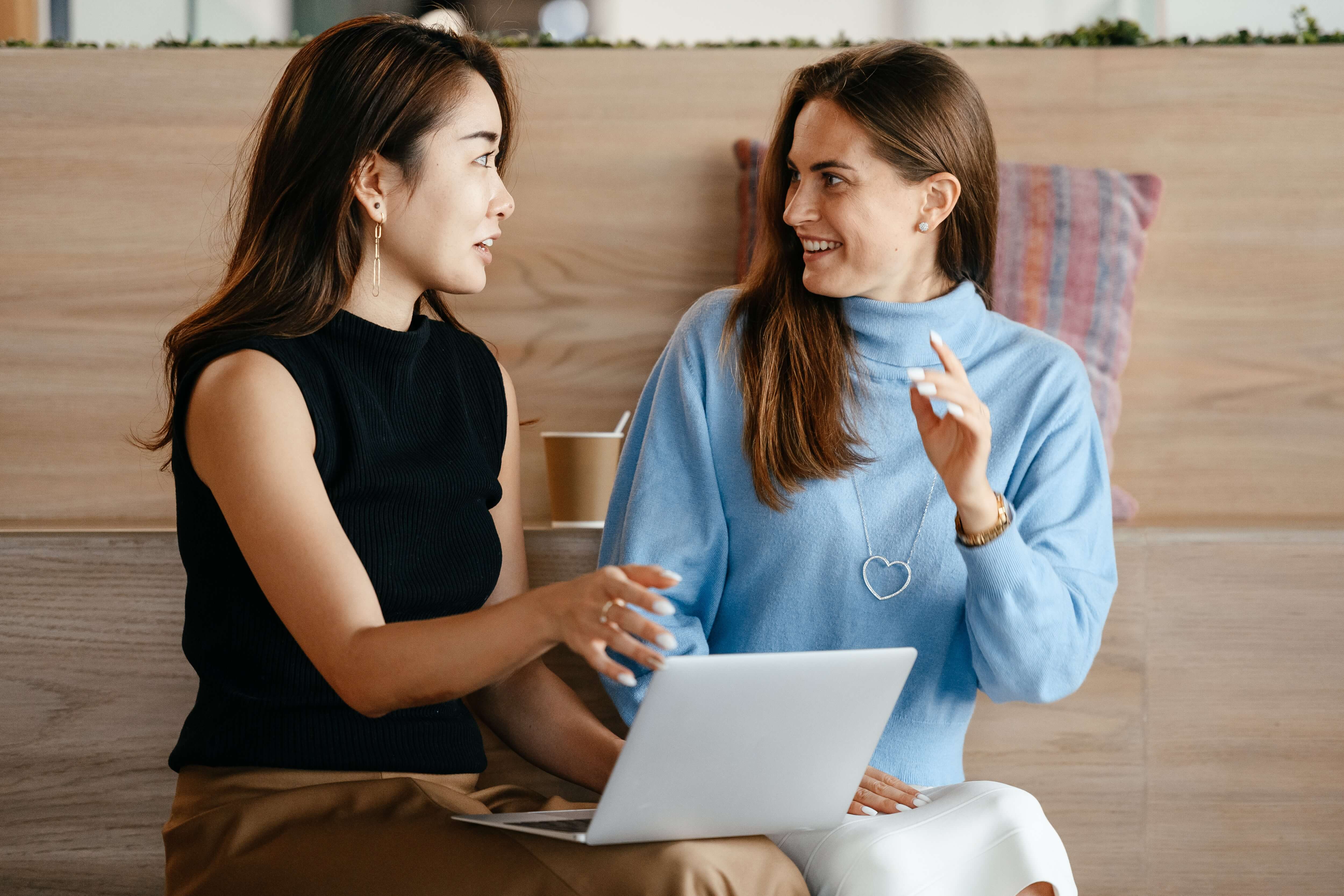 deux femmes assises discussion ordinateur